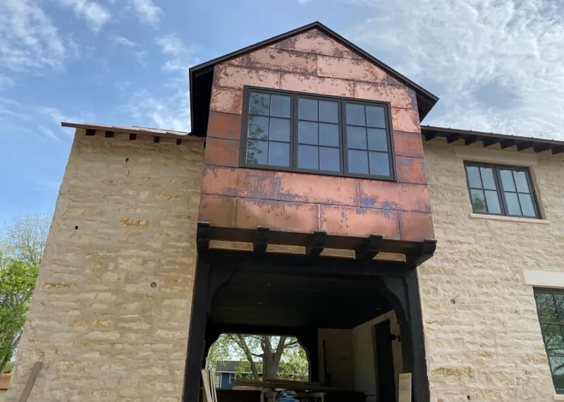 Copper metal panel facade on a stone building for Roof Repair in Davison